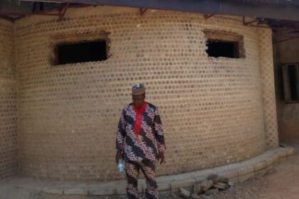 engenheiro-nigeriano-transformou-lixo-em-moradia-ao-encher-14,8-mil-garrafas-plasticas-com-areia,-amarrar-os-gargalos-e-usa-las-no-lugar-de-tijolos-para-erguer-uma-casa-de-tres-quartos,-cozinha-e-banheiro;-depois-repetiu-o-metodo-em-cerca-de-15-lares-que